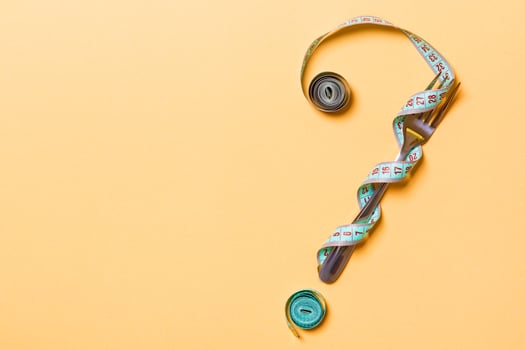 Top view of question mark made of fork and measuring tape on pink background. Diet concept with copy space photo