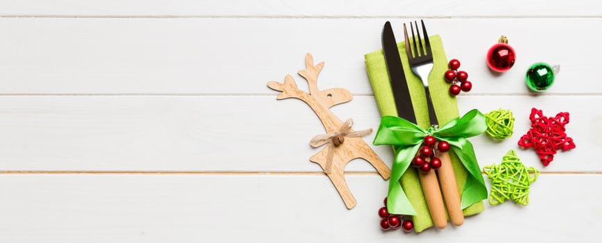 New year set Banner of fork and knife on napkin. Top view of christmas decorations and reindeer on wooden background. Holiday family dinner concept with empty space for your design photo