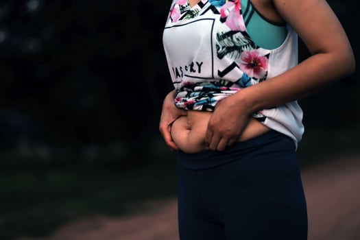 Women body fat belly. Obese woman hand holding excessive belly fat. diet lifestyle concept to reduce belly and shape up healthy stomach muscle. photo