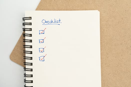 Top view of notebook with handwritten Checklist text. Checklist concept, checklist box with red checkmark. photo