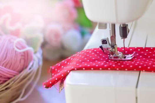 Close up of sewing machine working with red fabric photo