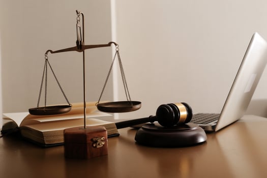 Business and lawyers discussing contract papers with brass scale on desk in office. Law, legal services, advice, justice and law concept picture with film grain effect photo