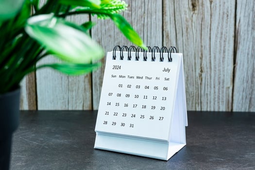 White July 2024 calendar on wooden desk. 2024 New Year Concept photo