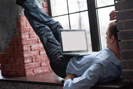 A man looks at a blank computer screen display. The man lies on photo