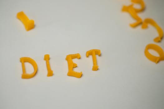 word DIET consists of edible letters. Pasta Diet Food. Pasta in form of letters on gray background. Proper nutrition concept. photo