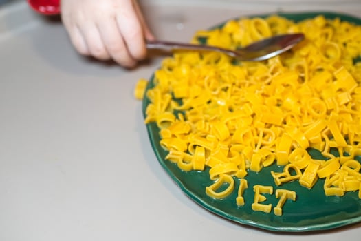 macaroni alphabet letters on a green plate. photo