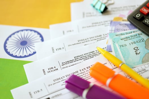 KYIV, UKRAINE - MAY 4, 2022 Indian income tax return blank form with pen and indian rupees bills photo