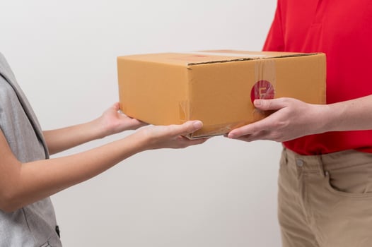 Asian man delivery sending cardboard box to woman over white background photo