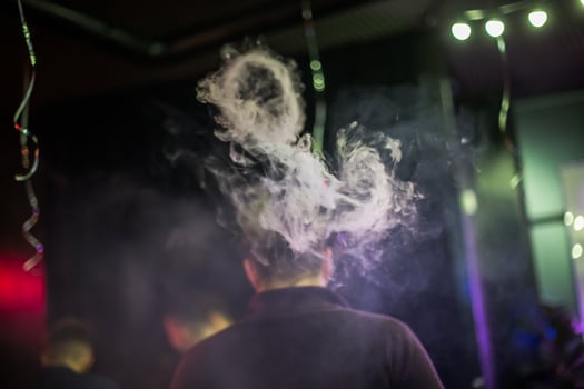 Circle of smoke from electronic cigarettes. Couples from vape. Smoke from the mouth of a smoking man. Men vaping and lets out circles of smoke. photo