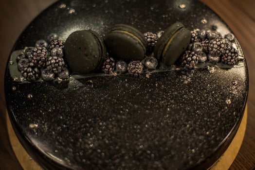 Black chocolate cake on a wooden table. Decorated with chocolate chip cookies birthday cake on a restaurant photo