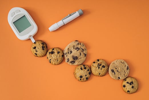 Determining the approximate concentration of glucose in chocolate cookies. Creative medical device and sweet chocolate cookies concept. Minimal flat lay medical background idea. photo