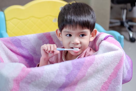 A boy brushes his teeth in his beloved toy box. photo