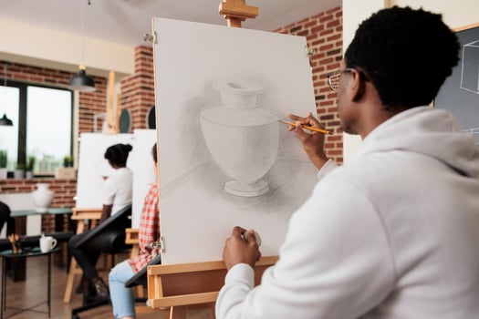 Young people friends attending drawing class, learning new skills together. Rear view of African American student guy sketching vase with pencil during group art lesson. Creativity and selfdiscovery photo