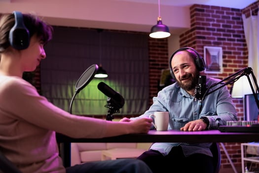 Happy show host interviewing woman during live stream, talking about fashion and style trends. Man talking with social media star, recording episode for online podcast channel photo