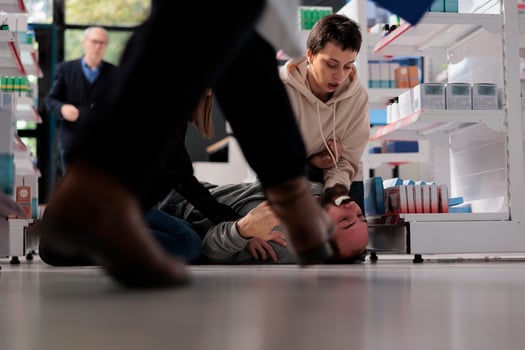 Pharmacy customers helping man managing epilepsy attack, rushing to give first aid. Young person lying on floor and suffering from forthy saliva and convulsion movements seizure symptoms photo