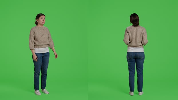 Furious negative adult standing on full body greenscreen, showing disappointment and disapproval over green screen backdrop. Frustrated upset model being angry and displeased in studio. photo