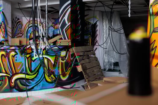 Old aged building covered in dust and debris, looking abandoned and neglected with crumbling structure. Empty damaged warehouse filled with graffiti artwork on walls, dirty rusty ghetto. photo