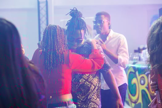 Romantic couple dancing together while partying in nightclub. African american boyfriend and girlfriend embracing, showing love and affection on dancefloor while clubbing photo