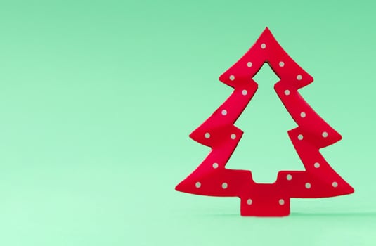 Minimalistic Christmas tree on pastel green background. Creative Christmas or New Year concept. Trendy holiday idea with copy space. photo