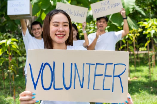 Happy young Asian students diverse volunteers hold a campaign sign for cleaning in the park, The concept of environmental conservation on world environment day, recycling, charity for sustainability. photo