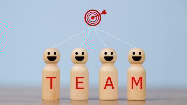 Wooden figures smile faces with team wording on the body and target icons. Teamwork and Ideas for business corporation concept. Business target and team concept. photo