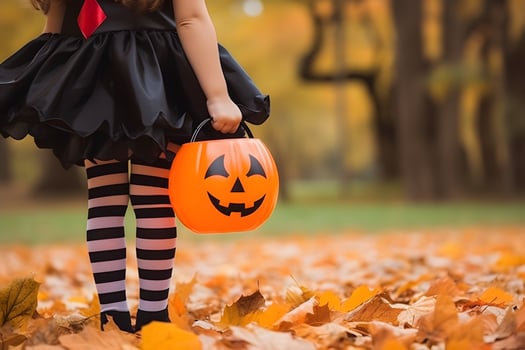 Kid going trick or treating. Child in festive Halloween costume with cute jack o lantern basket photo