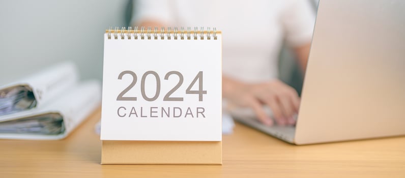 2024 Year Calendar on table with business woman using laptop computer. countdown, Happy New Year, Resolution, Goals, Plan,  Action, Mission and financial Concept photo