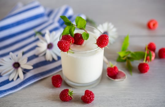 Sweet cooked homemade yogurt with fresh raspberries in a glass. photo