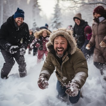 Kids and parents laughing during snowball fight in the forest photo