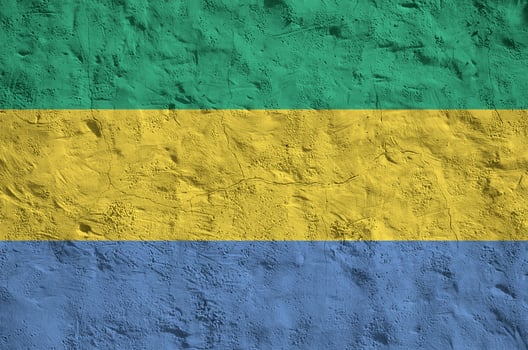 Gabon flag depicted in bright paint colors on old relief plastering wall. Textured banner on rough background photo