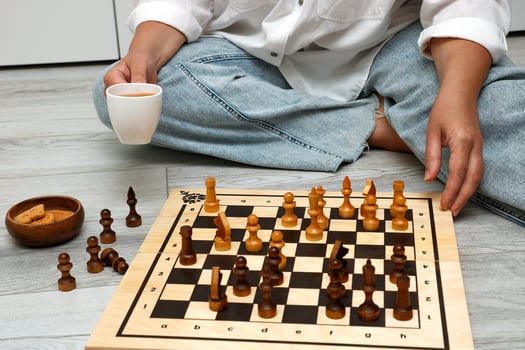 woman with a cup of tea playing chess at home. photo