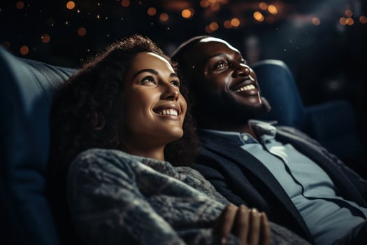 Woman cuddles with man while watching a movie. photo