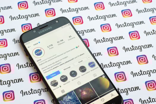 Nasa official instagram account on smartphone screen on paper instagram banner. photo