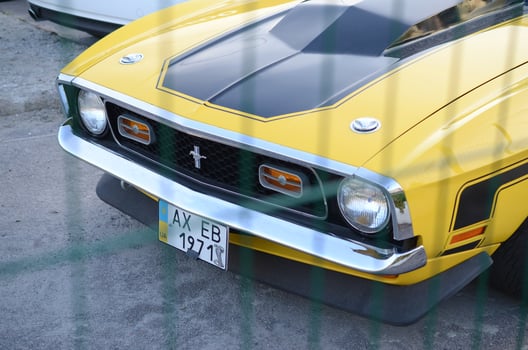 Front view of Ford Mustang Mach 1 in bright yellow color on public parking place photo