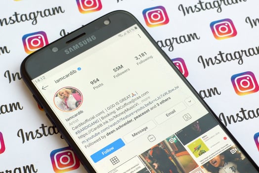 Cardi B official instagram account on smartphone screen on paper instagram banner. photo