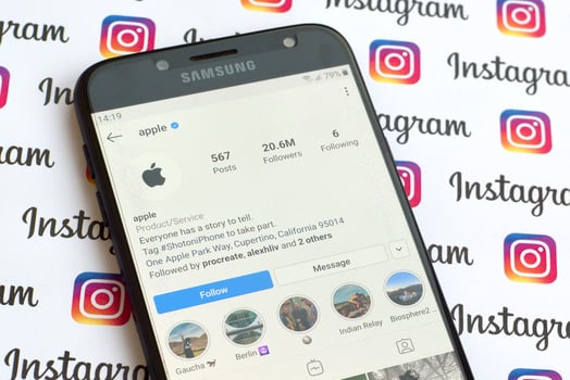Apple official instagram account on smartphone screen on paper instagram banner. photo