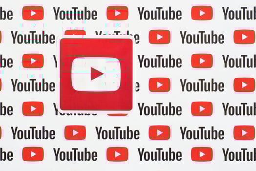 Youtube logo sticker on pattern printed on paper with small youtube logos and inscriptions. YouTube is Google subsidiary and American most popular video-sharing platform photo