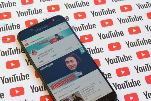Whinderssonnunes official youtube channel on smartphone screen on paper youtube background. photo