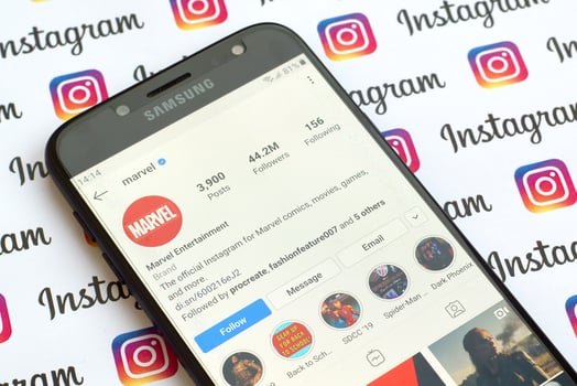 Marvel official instagram account on smartphone screen on paper instagram banner. photo