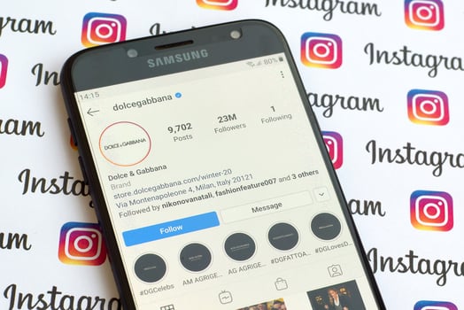 Dolce and Gabbana official instagram account on smartphone screen on paper instagram banner. photo