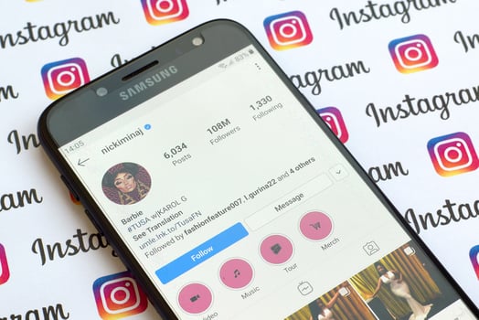 Nicki Minaj official instagram account on smartphone screen on paper instagram banner. photo