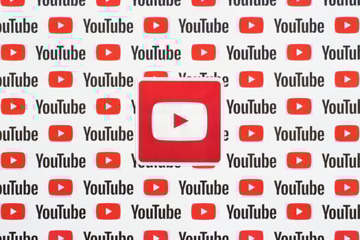 Youtube logo sticker on pattern printed on paper with small youtube logos and inscriptions. YouTube is Google subsidiary and American most popular video-sharing platform photo