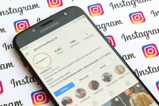 Givenchy official instagram account on smartphone screen on paper instagram banner. photo