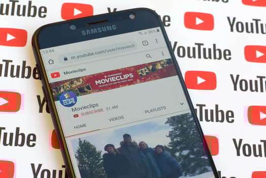 Movieclips official youtube channel on smartphone screen on paper youtube background. photo