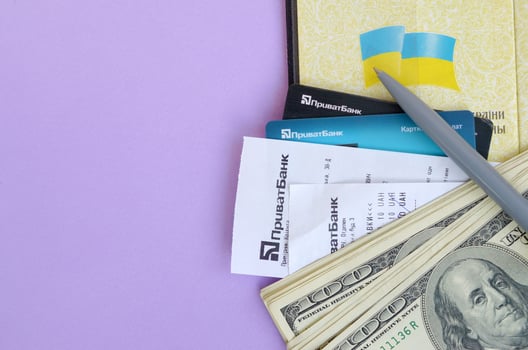 Privatbank check lies with credit cards and pen on dollar bills with passport. Privatbank is a main financial department in Ukraine, depository of money in hryvnia photo