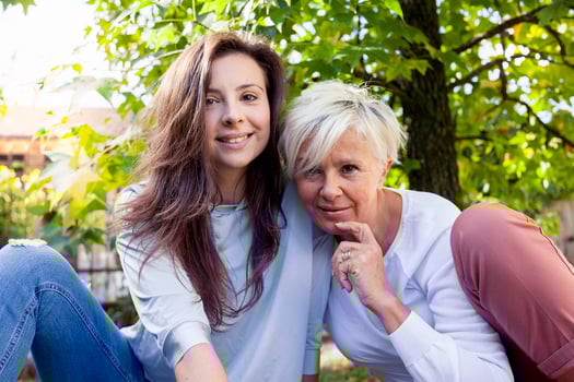 pretty mom and daughter consult the laptop under a tree in autumn photo