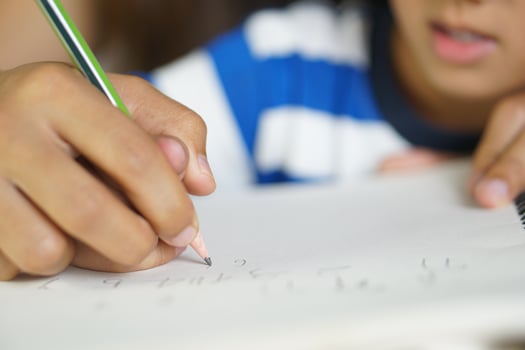 Mother holds hands with son to practice writing letters photo