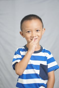 The boy stuck his finger into his nose. photo