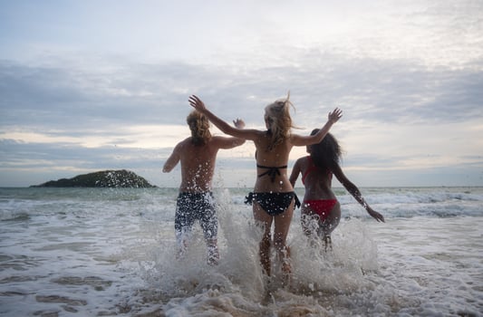 Group of friends having fun on the beach at the sunset time. photo