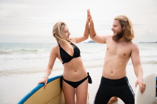 Two surfers giving high five on the beach. Two surfers having fun on the beach. photo